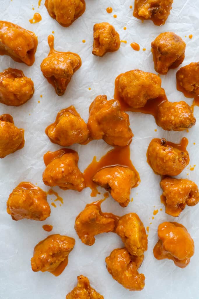 Cooked cauliflower coated in orange sauce.