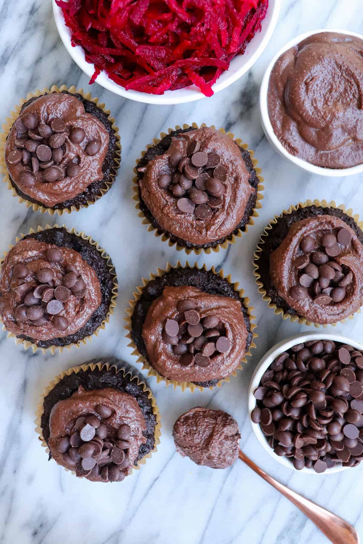 Top view shot of muffins. Bowl of grated beetroot on side for decoration.