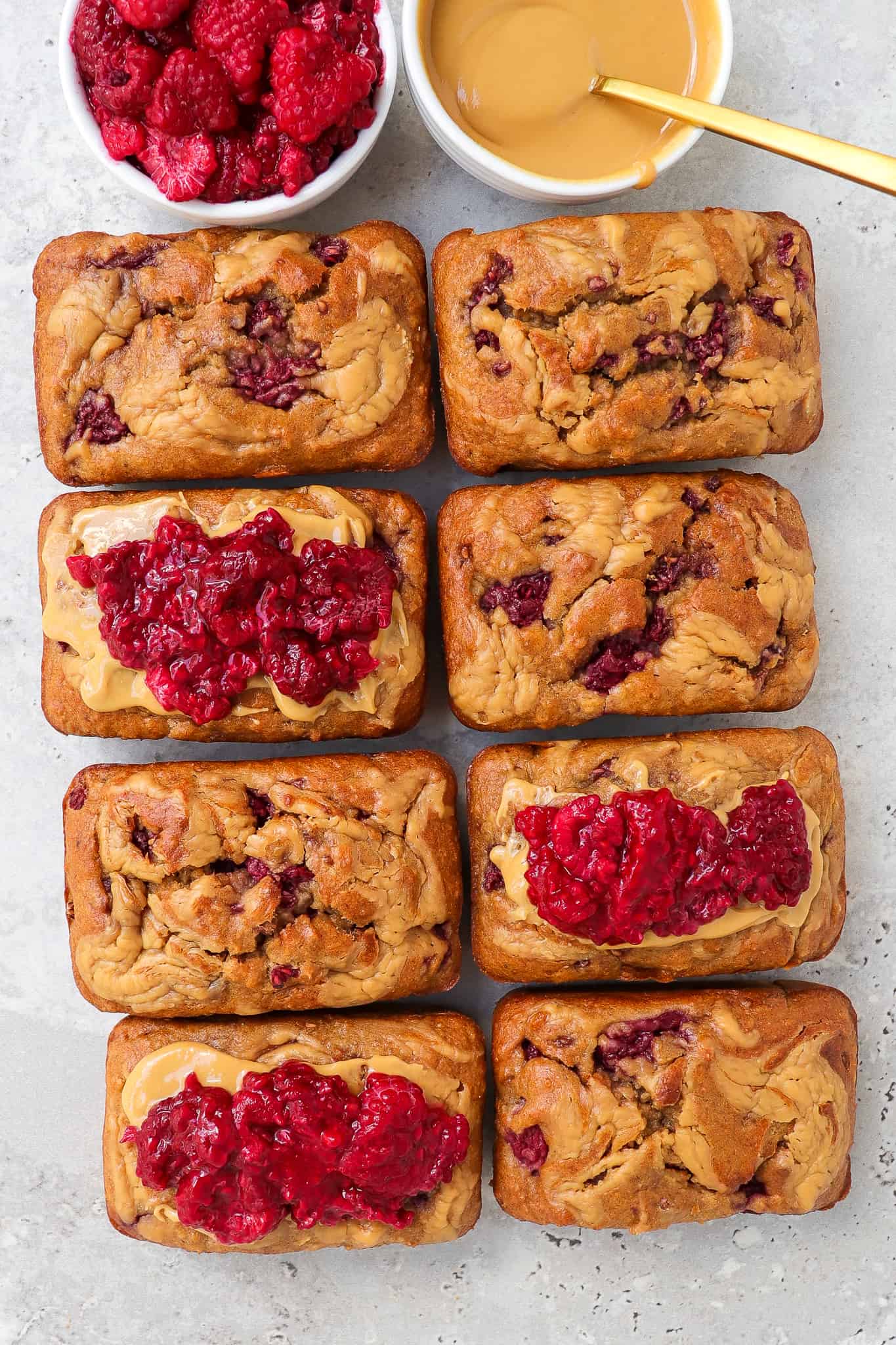 Some breads topped with extra peanut butter and mashed raspberries.