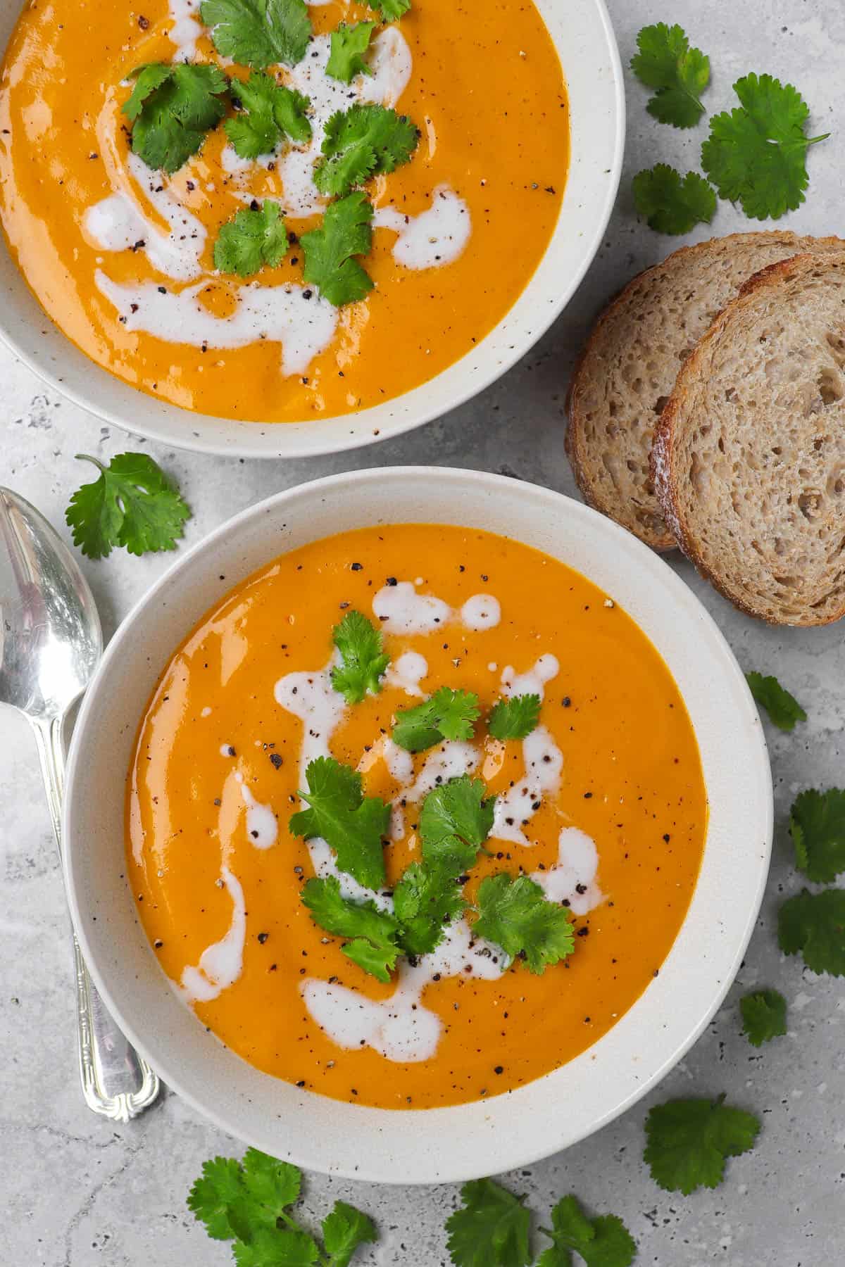 Soup in a bowls. Spoon and sourdough on the sides.
