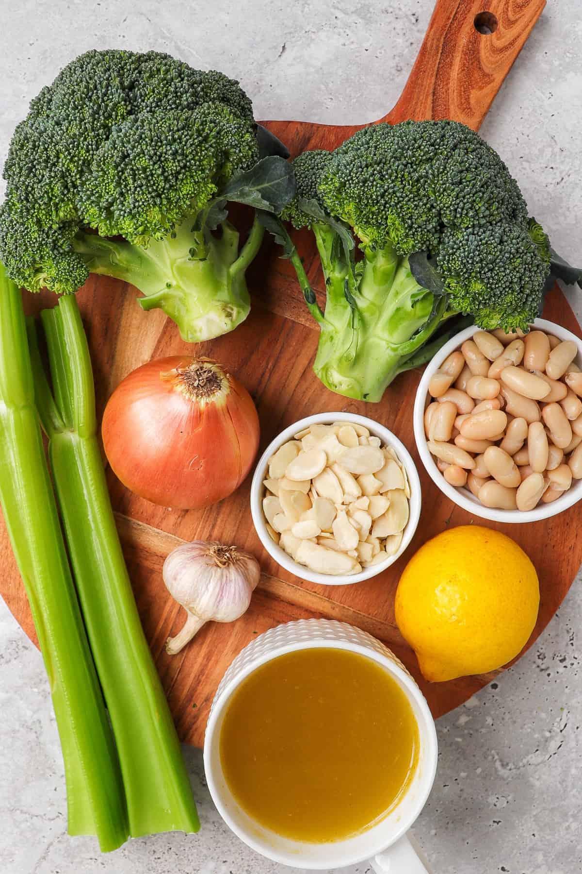 Broccoli almond soup ingredients on a wooden board.