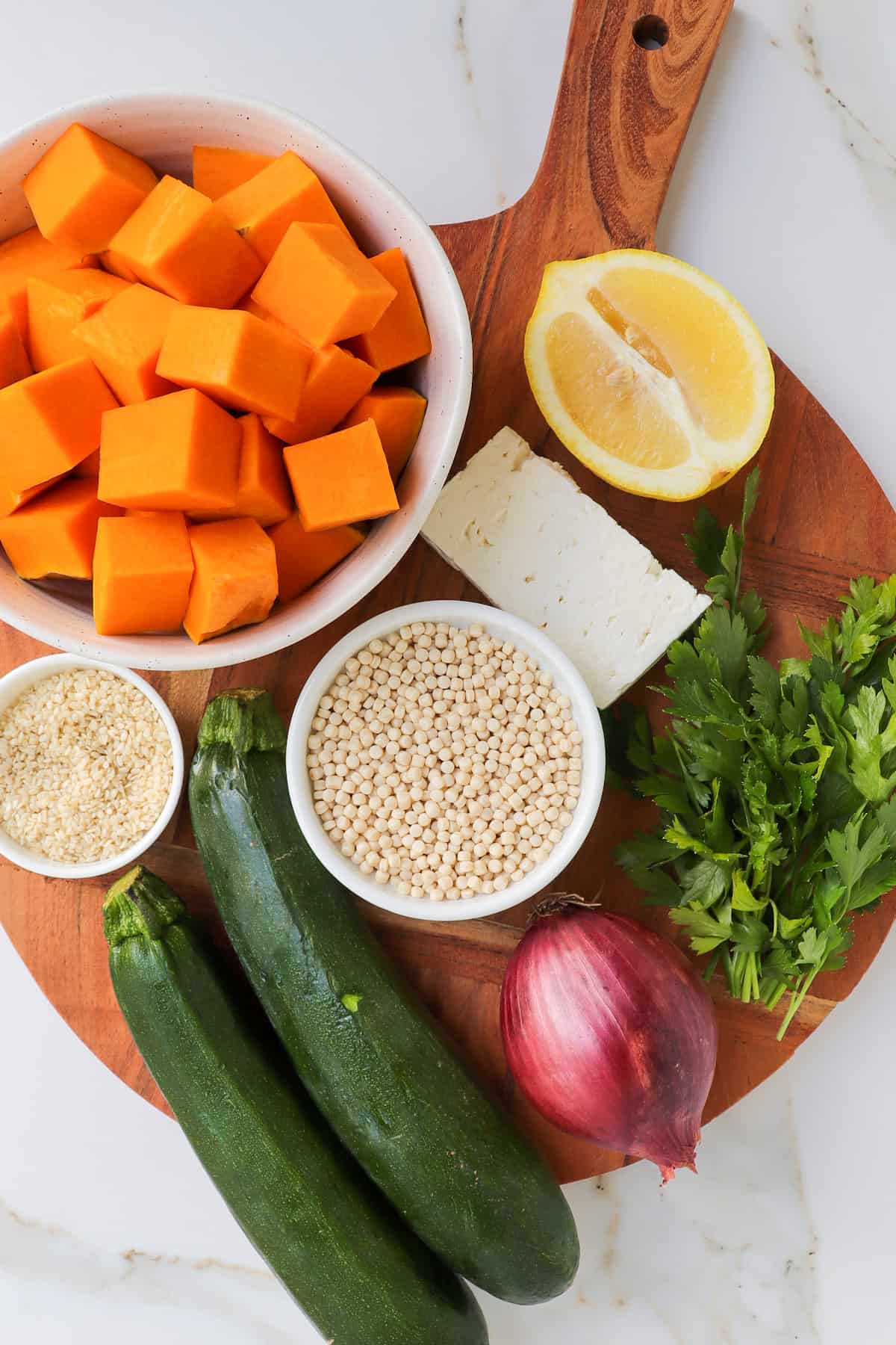Ingredients on wooden board for the pumpkin couscous salad.