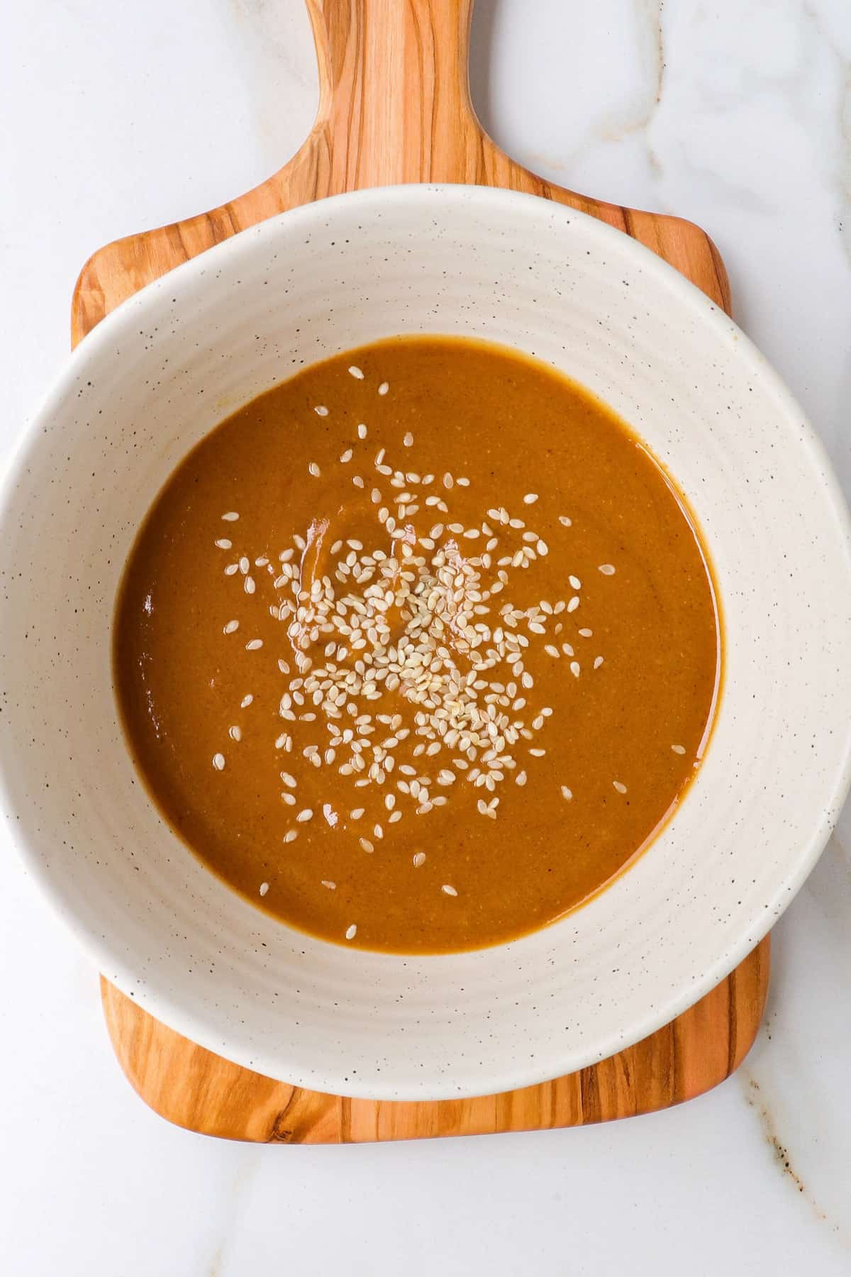 Ginger miso sauce in a bowl with sesame seeds.