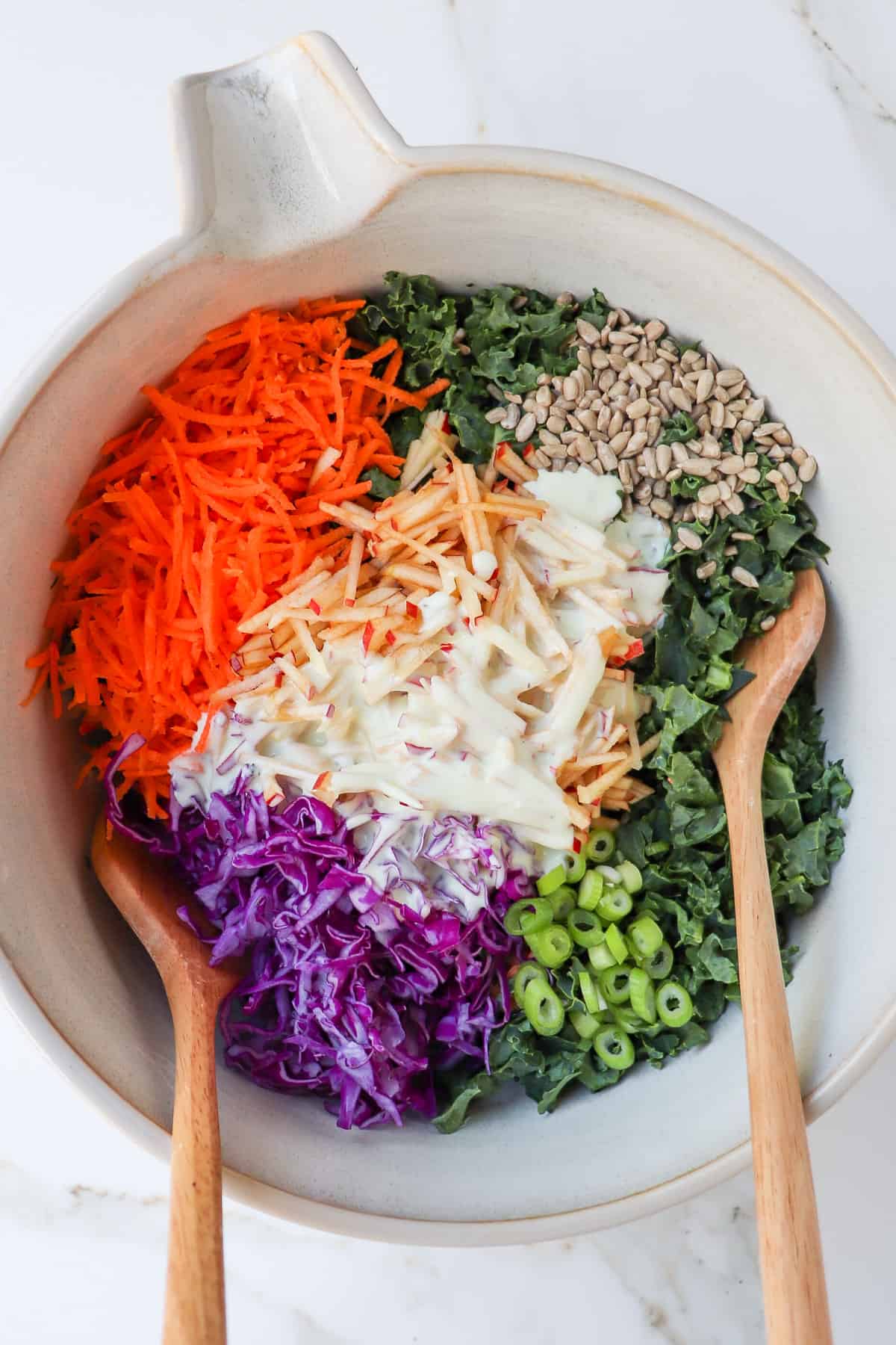 Kale and apple slaw ingredients in a mixing bowl before being combined.