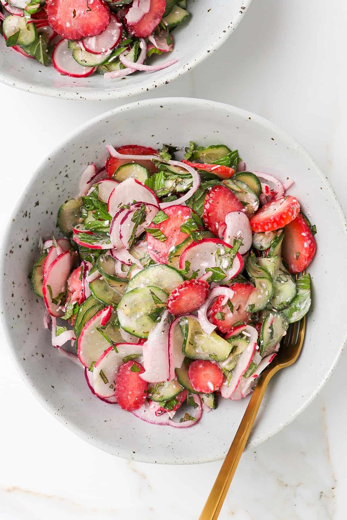 Salad served in a bowl with a gold fork.