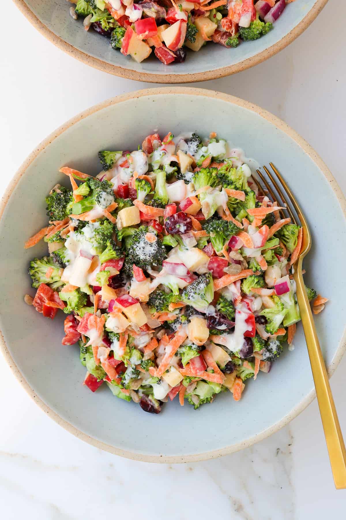 Broccoli salad in a bowl with a fork.