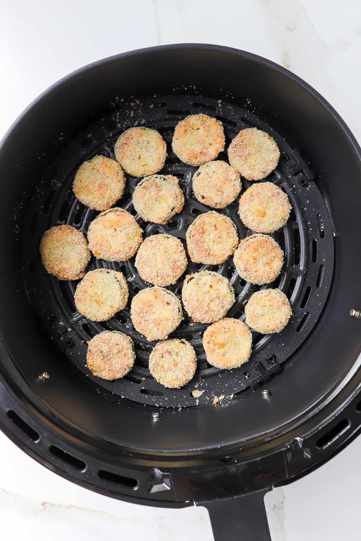 Crispy cucumbers in air fryer basket.