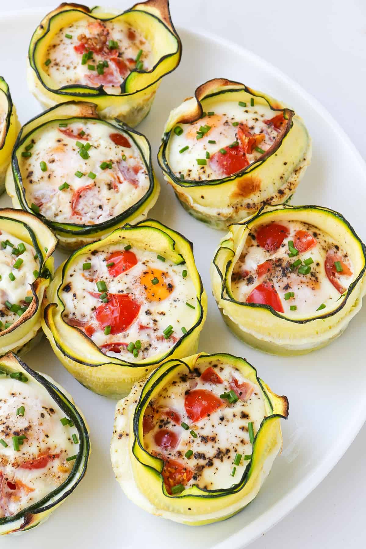 Side shot of zucchini egg cups on a plate.