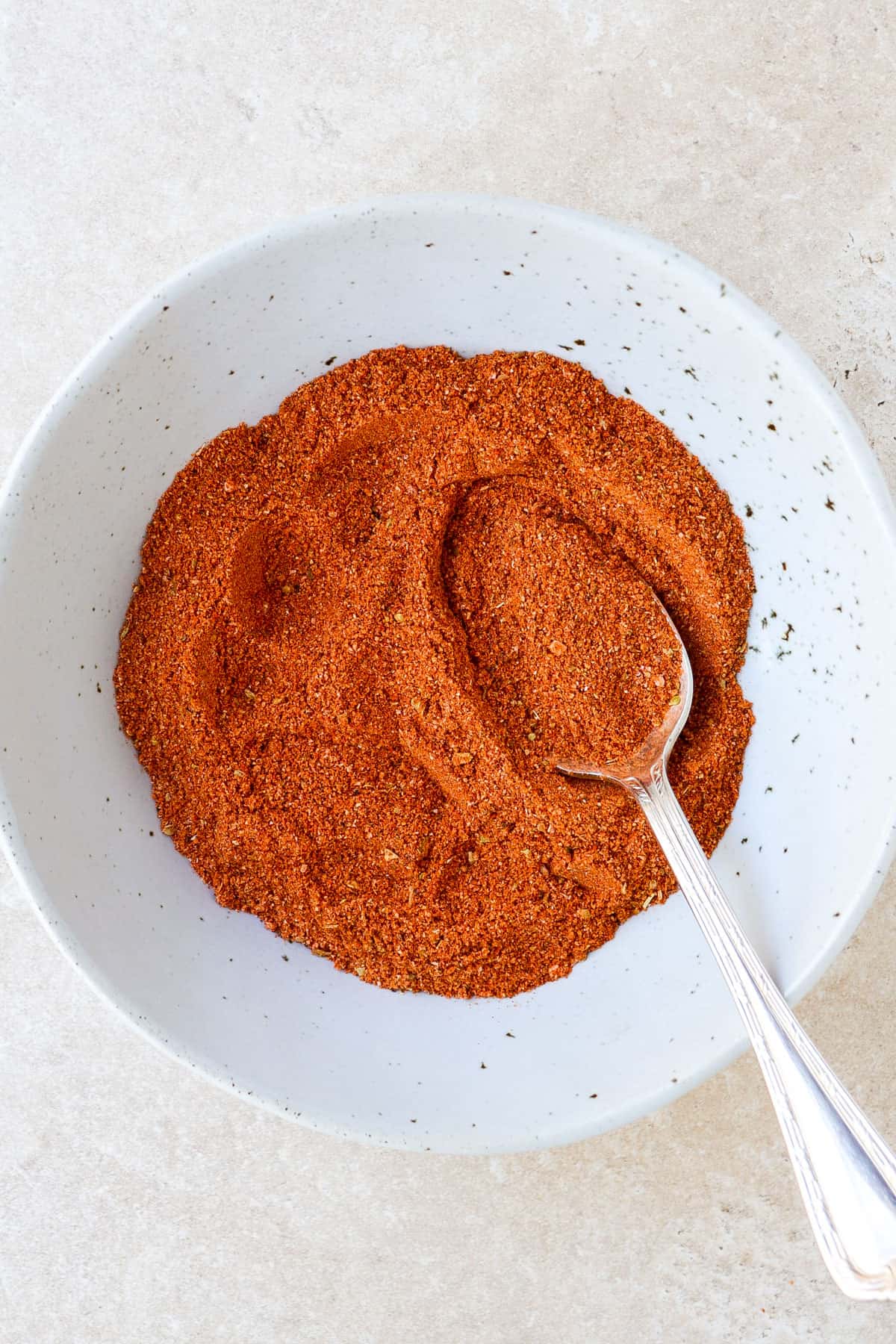 Homemade seasoning in a bowl with a spoon.