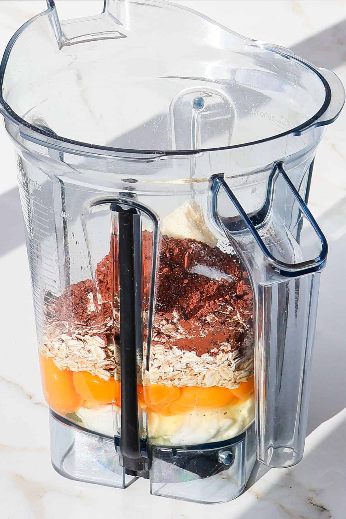 Side shot of ingredients in a blender jug.