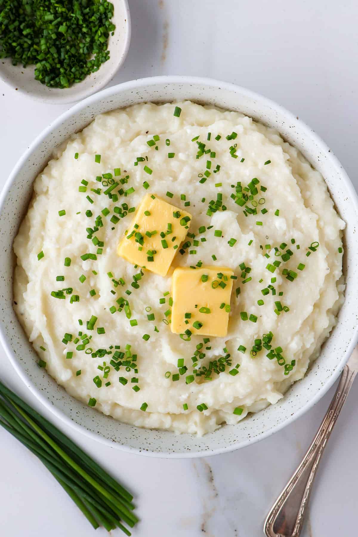 Mashed potatoes in a bowl. With a spoon on the side.