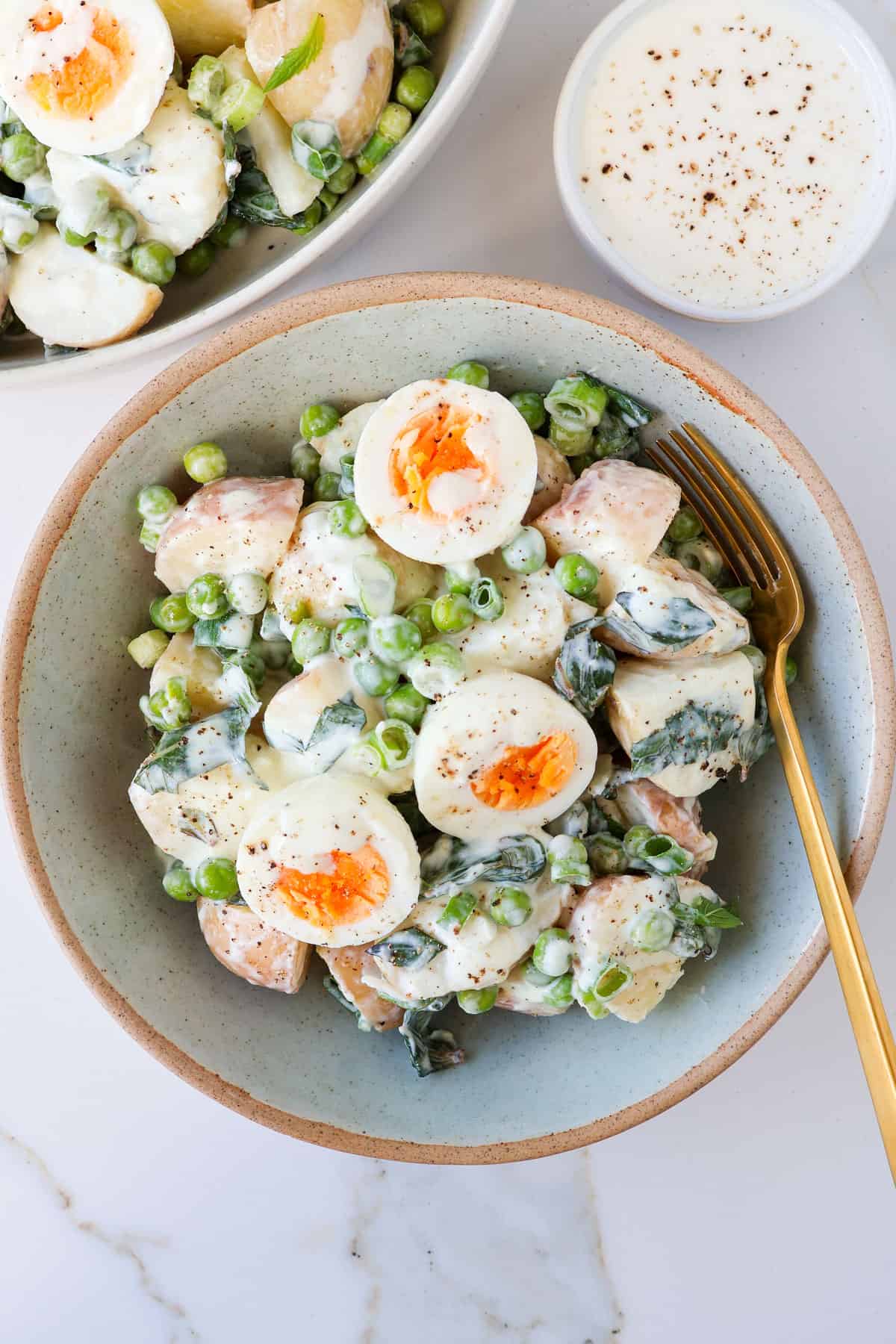 Spring onion potato salad served in a blue bowl.