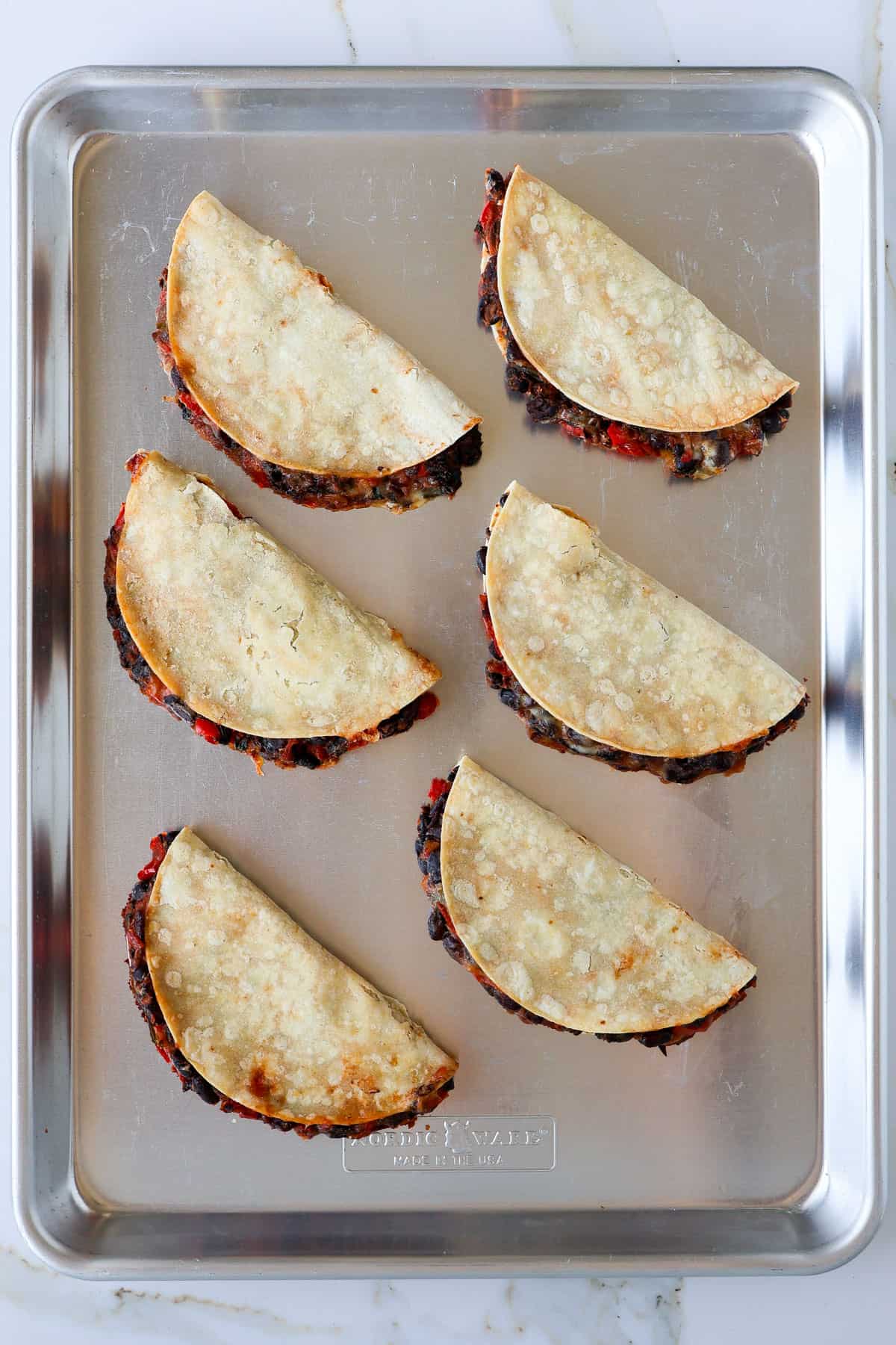 Baked black bean tacos on a sheet pan.