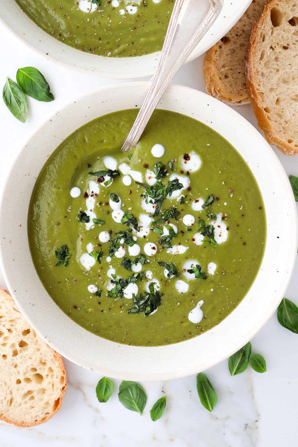 Broccoli pea soup in a bowl with a spoon.