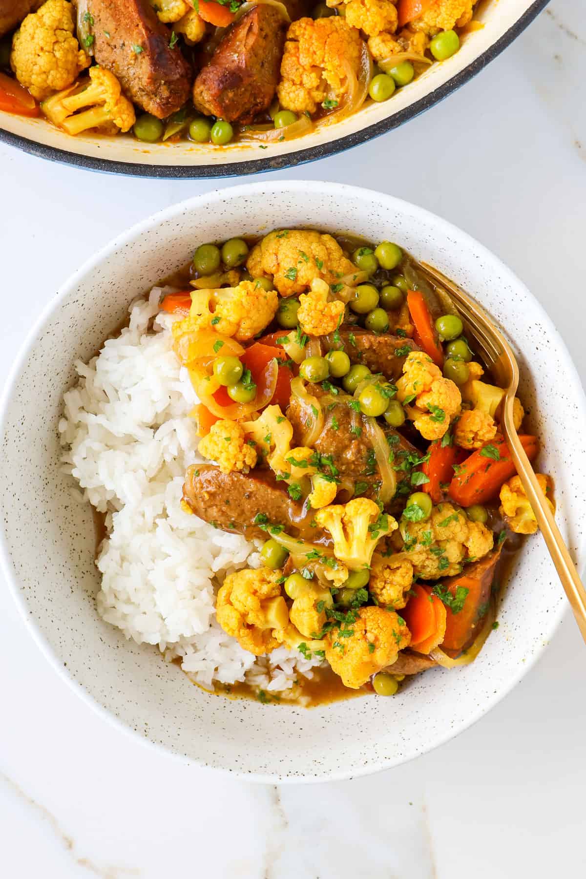 Sausage curry served in a bowl with rice.