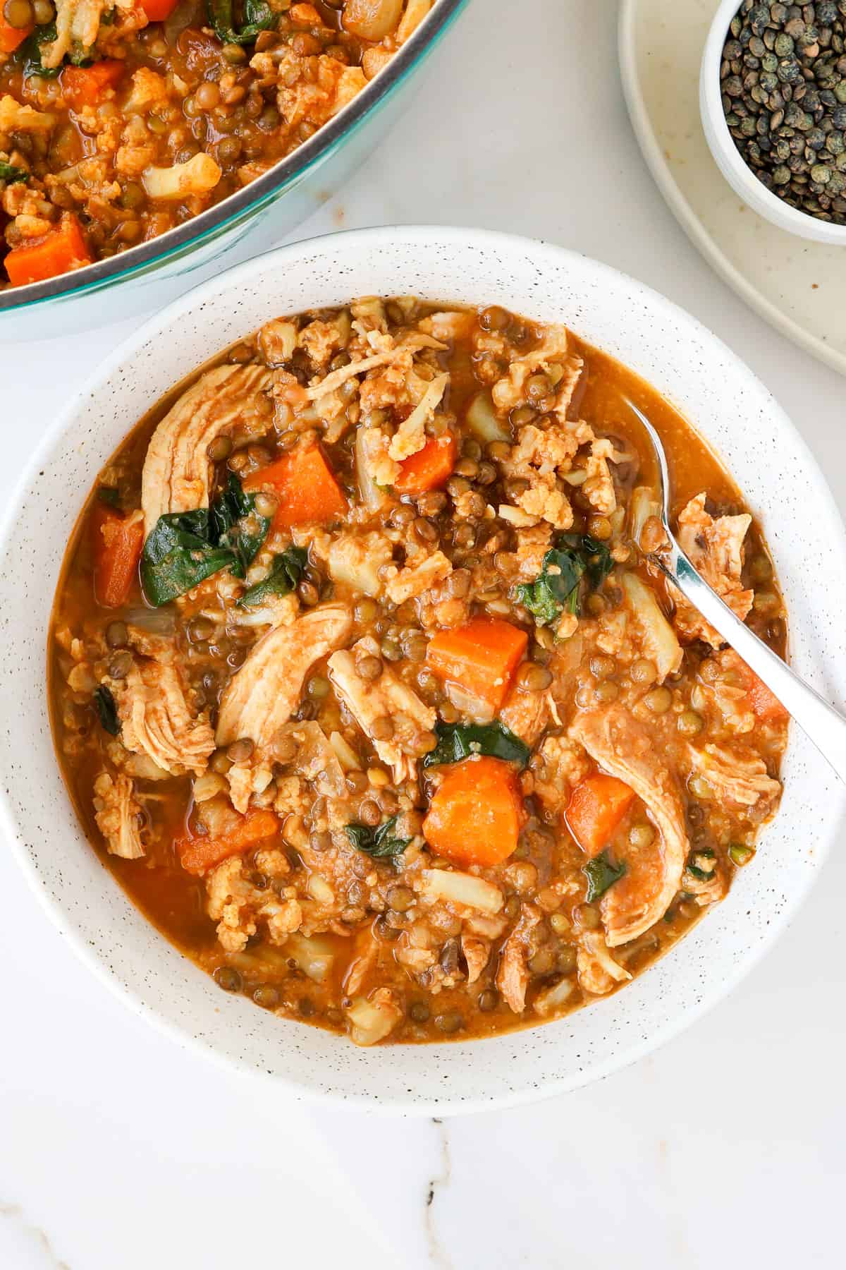 Chicken stew in a bowl with a spoon.