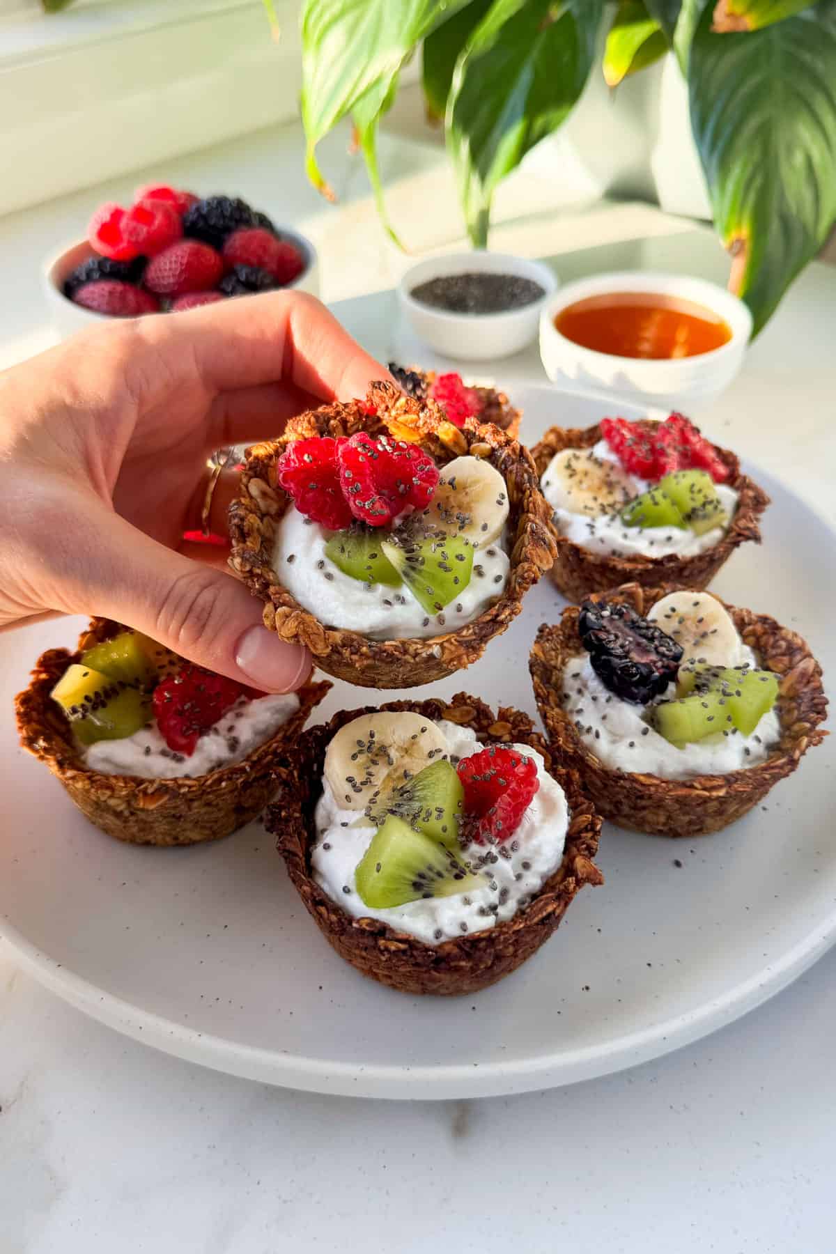 Side shot of granola yogurt cup in hand.